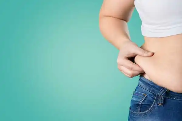Image of woman pinching her love handles to show weight gain Sheffield